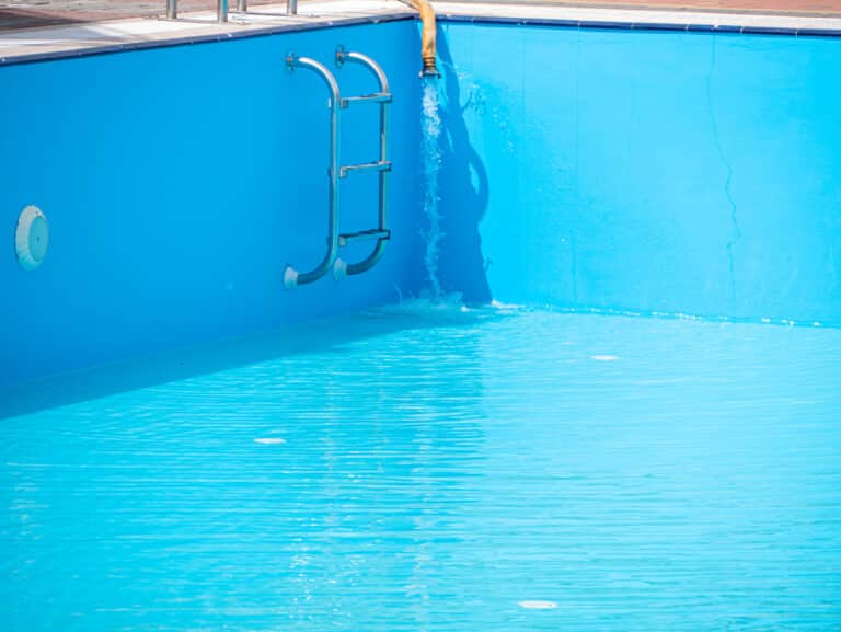 A pool is refilled with water after being drained to fix a pool leak