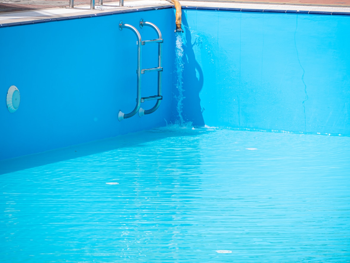 A pool is refilled with water after being drained to fix a pool leak