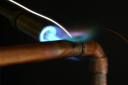 Soldering copper pipe with torch.