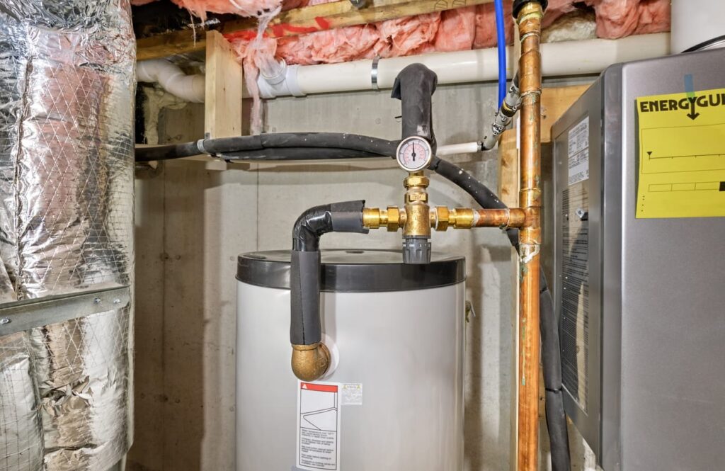 Pipes leading from a water heater in a basement. 