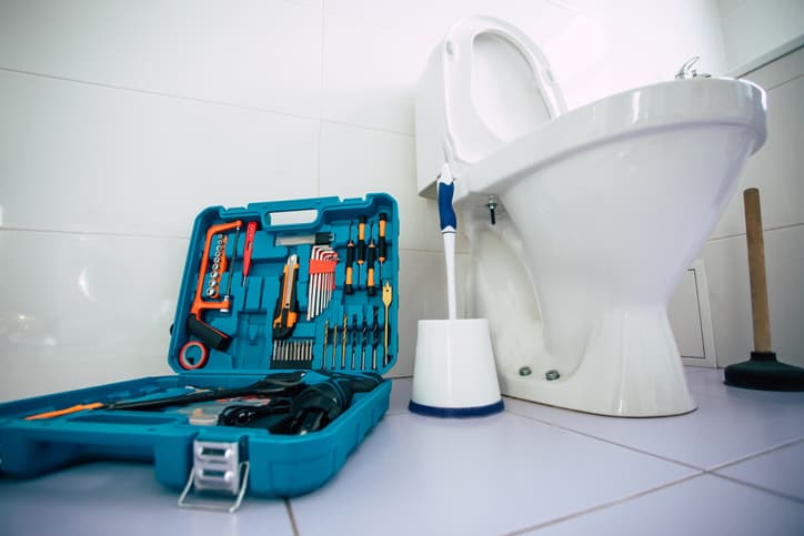 set of tools sitting on the floor near a toilet
