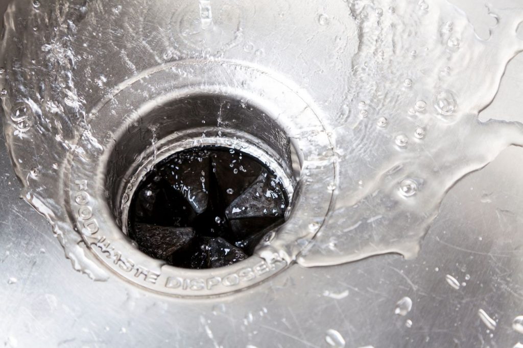 Water running into kitchen sink drain and into garbage disposal