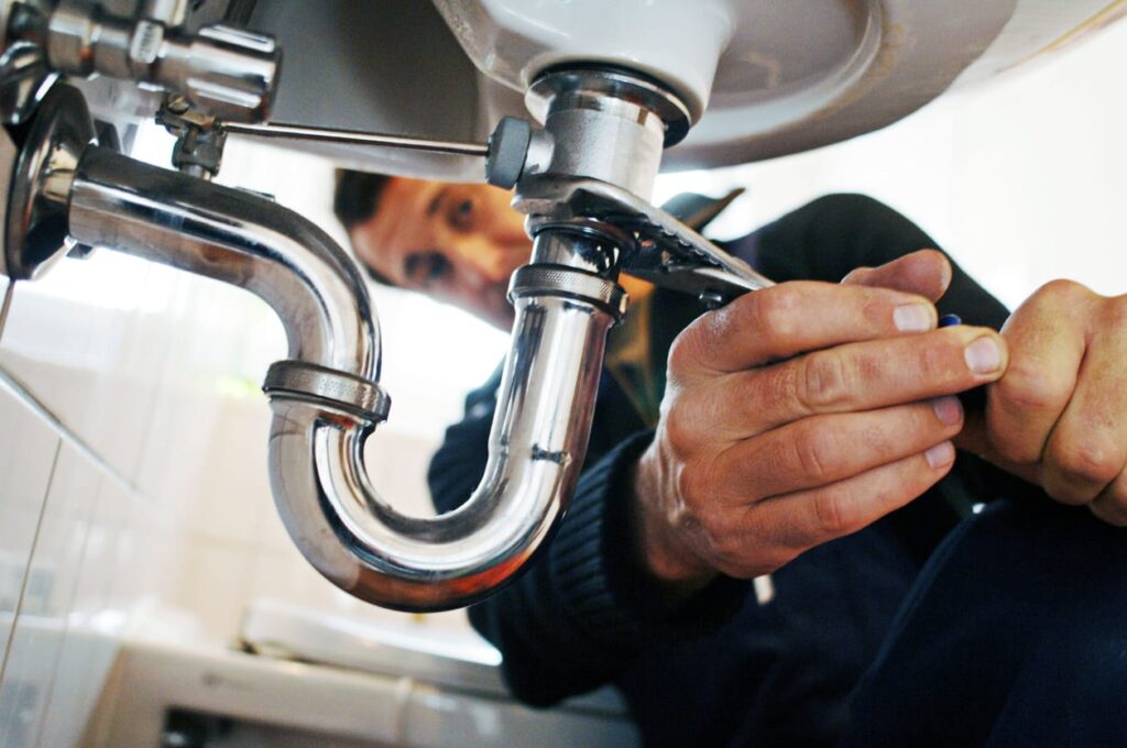 A plumber working on sink pipes in Las Vegas.